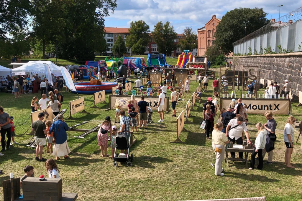Besökare vid MountX-stationer uppställda på en gräsyta under ett stadsevent